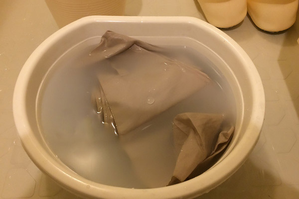 Folding umbrella soaking in reused Nikwax bath